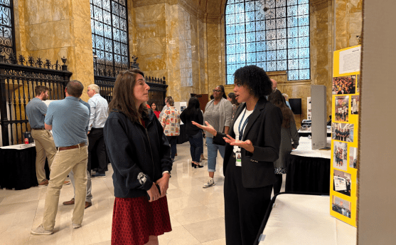 An intern talking with President Beth Hammack in the Federal Reserve Bank of Cleveland's historic lobby.